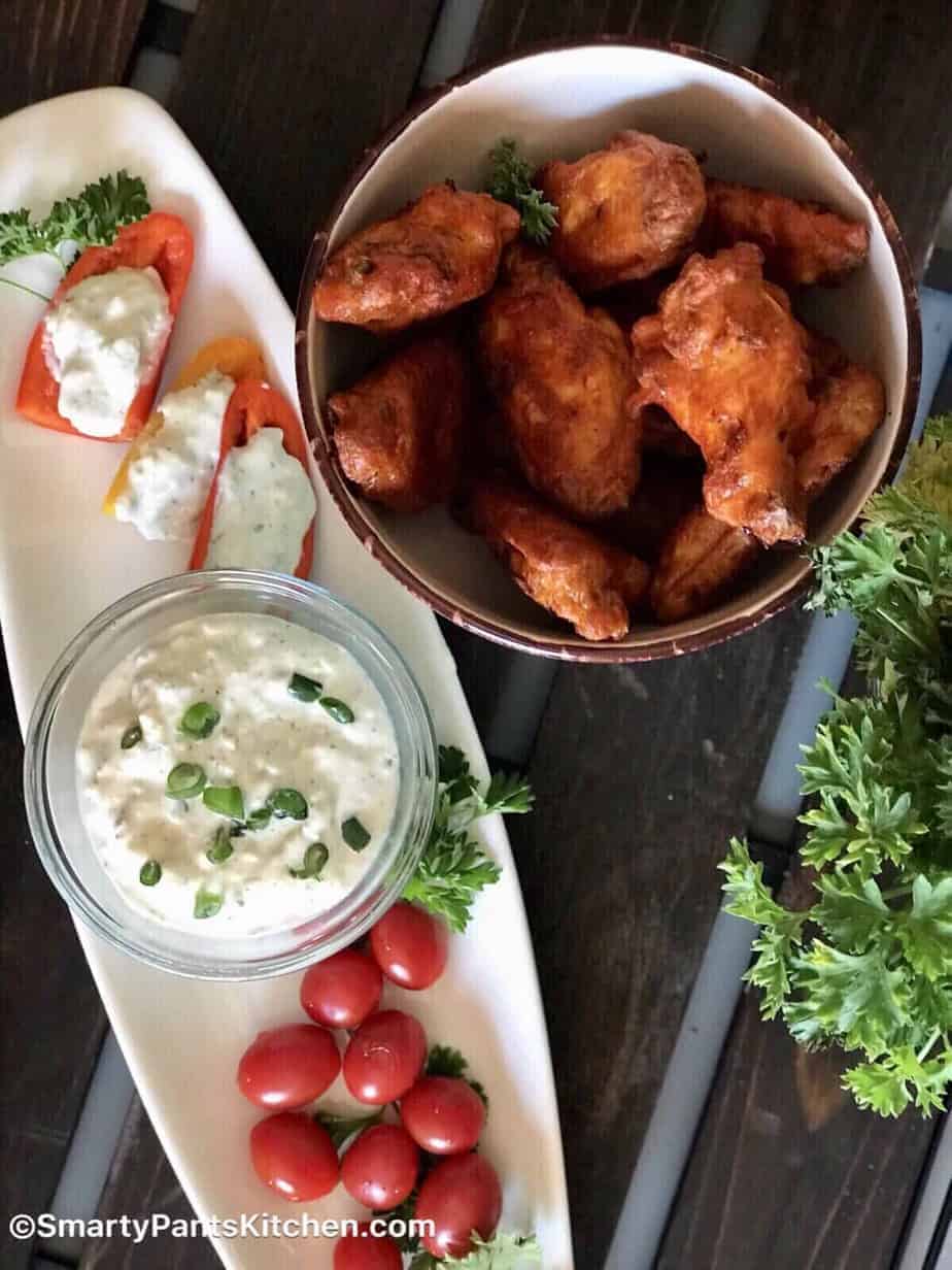 Bleu Cheese Dip on red and yellow bell peppers with a side of cherry tomatoes and chicken wings.