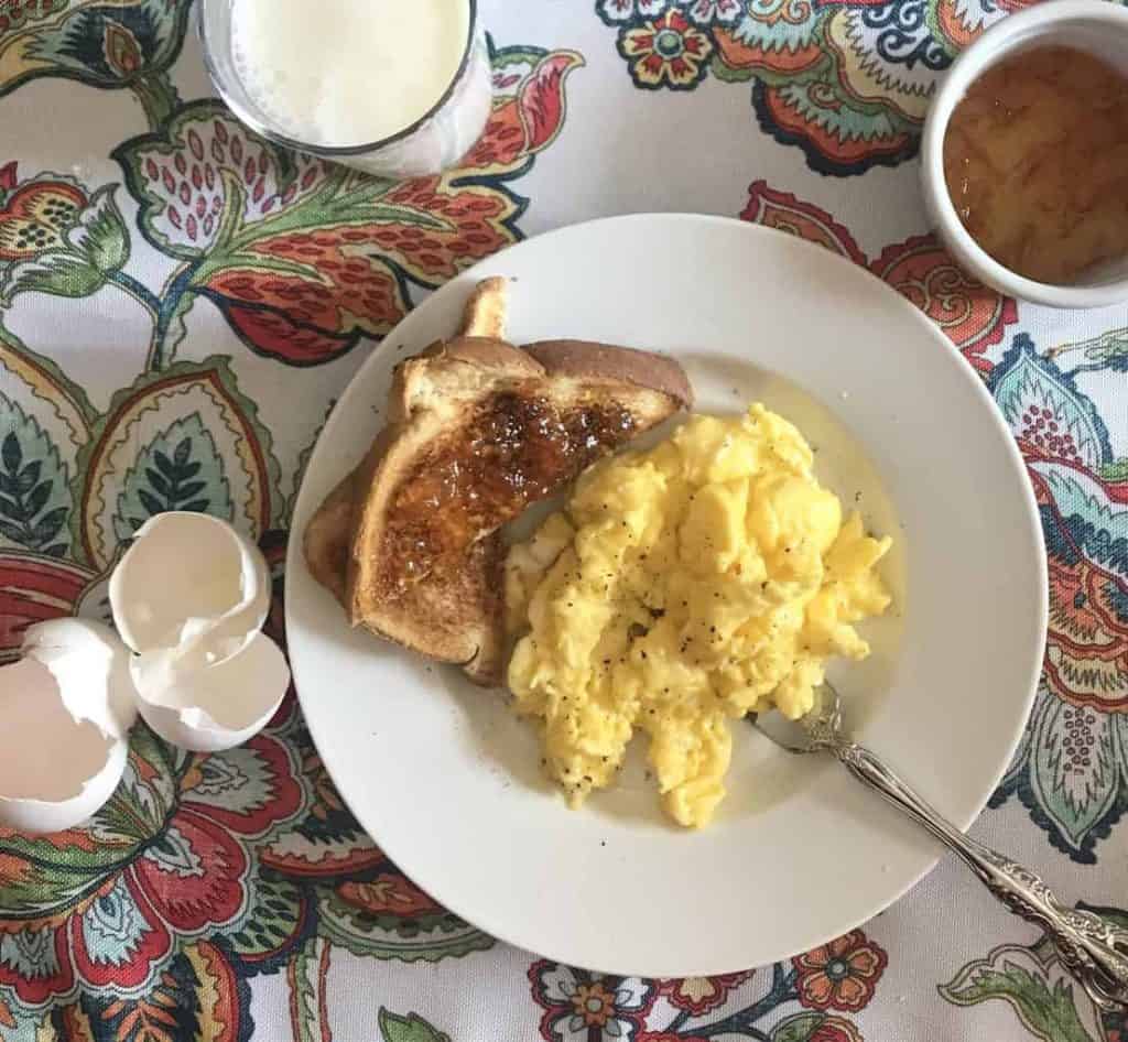 Scrambled eggs and toast on plate.