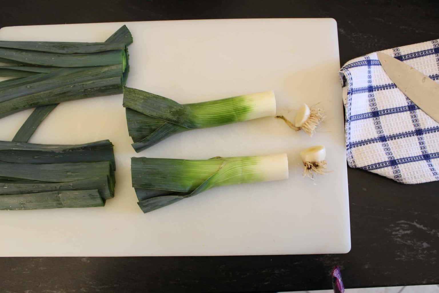 Leeks on cutting board with ends cut off
