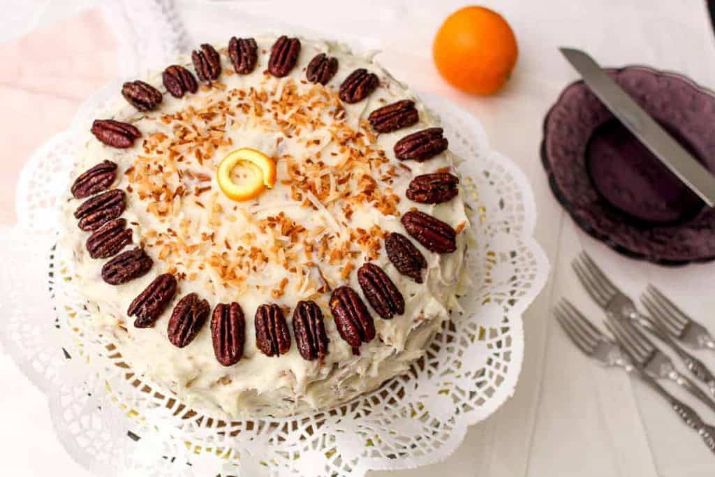 Orange Italian Cream Cake topped with toasted coconut and glazed pecans