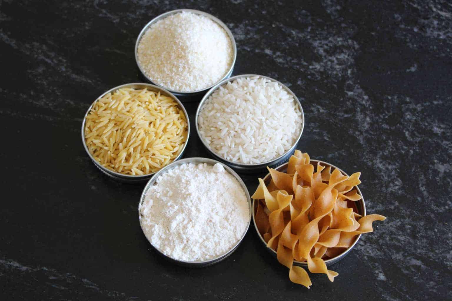 5 ramekins with grains on countertop rice, ,pasta, noodles, flour, cornstarch