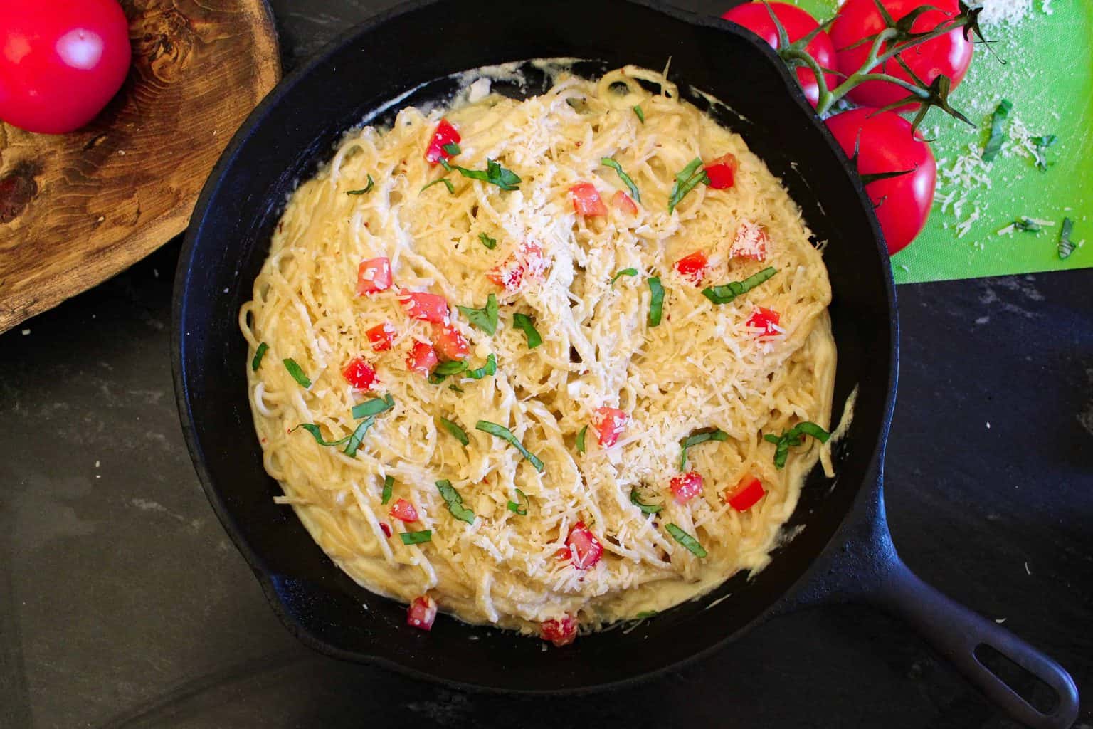 Creamy pasta carbonara with ricotta cheese garnished with tomatoes and basil