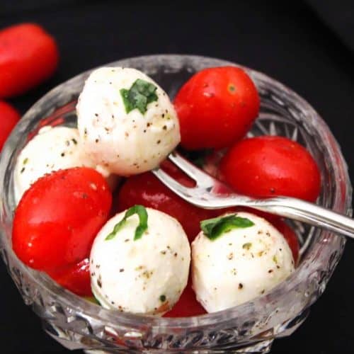 Caprese salad in glass bowl garnished with basil