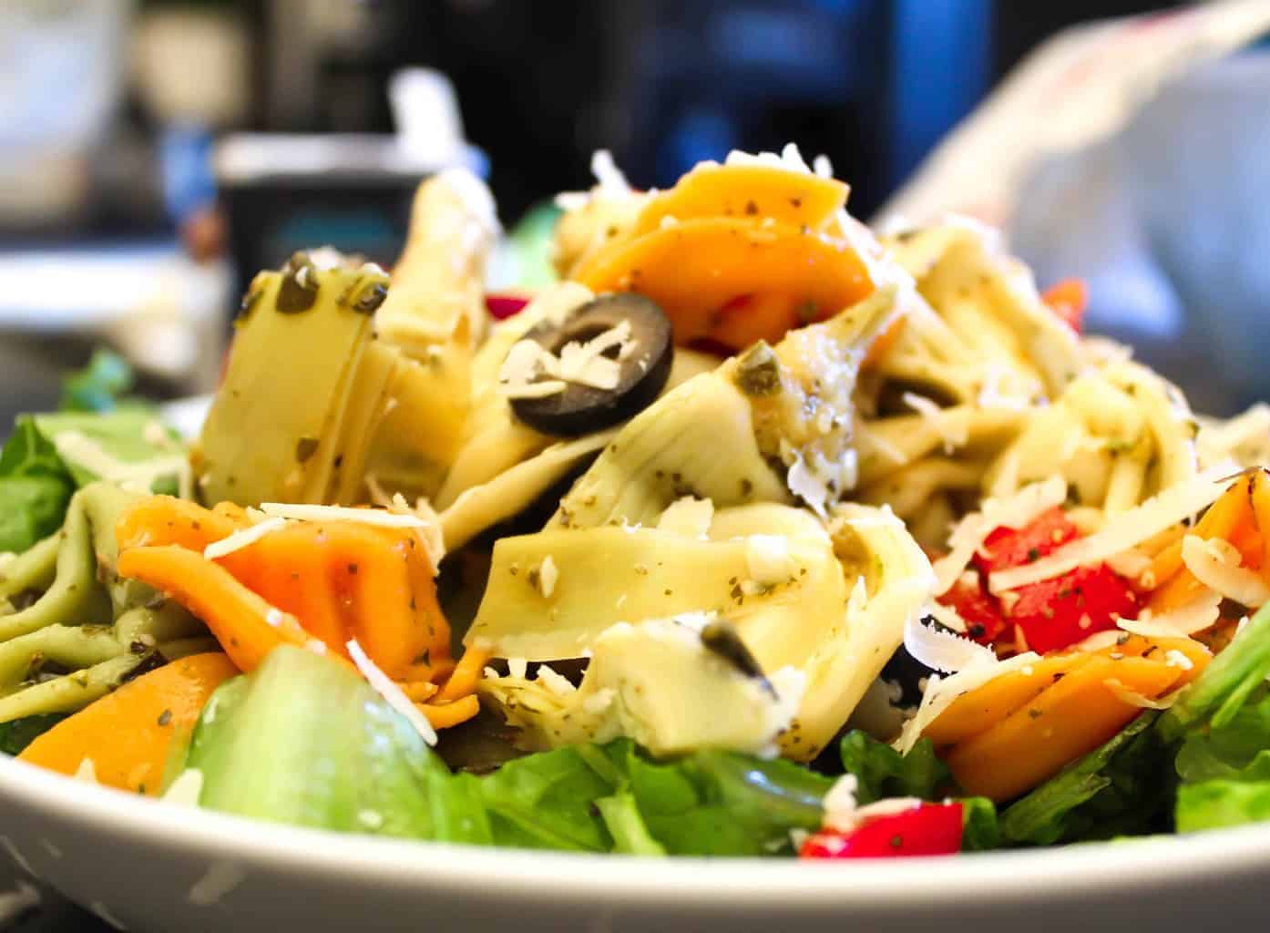 Tortellini Pasta Salad garnished with shredded mozzarella cheese