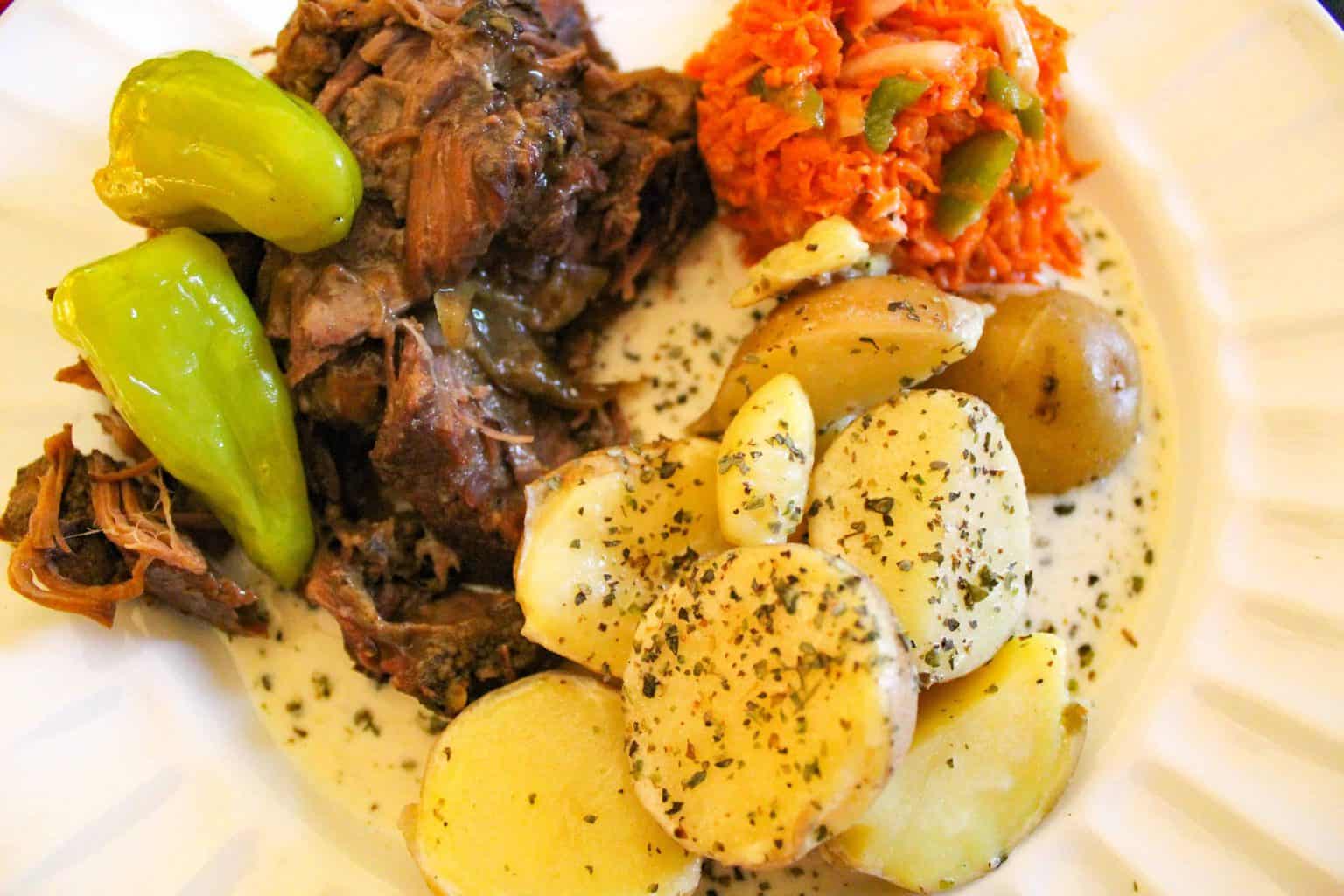 Mississippi Pot Roast with Gravy, cream potatoes and carrot slaw on white plate