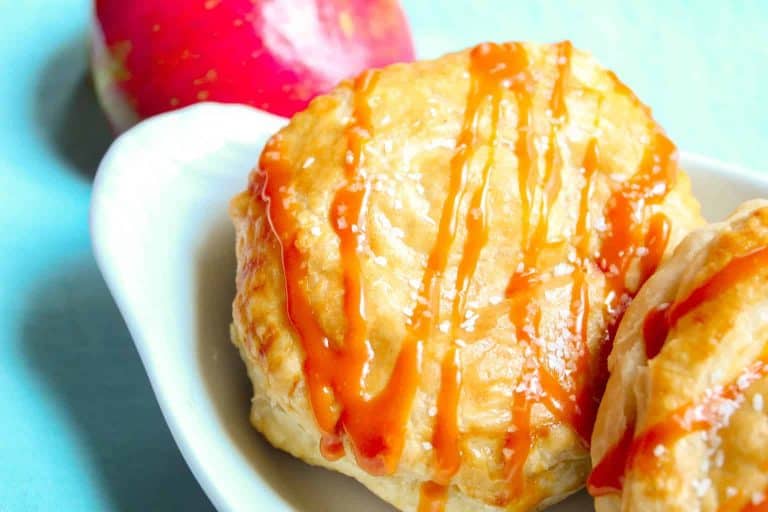 Puff pastry drizzled with caramel sauce with red apple on the side