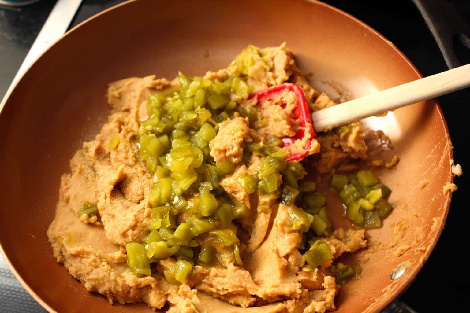 Beans in a skillet with green chiles.