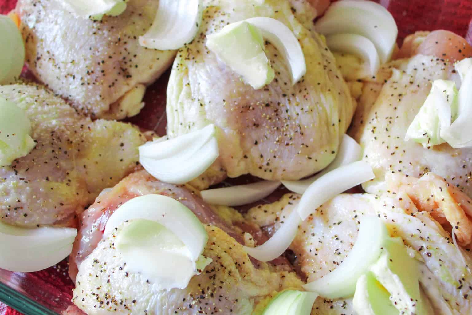 Seasoned chicken thighs in glass baking dish