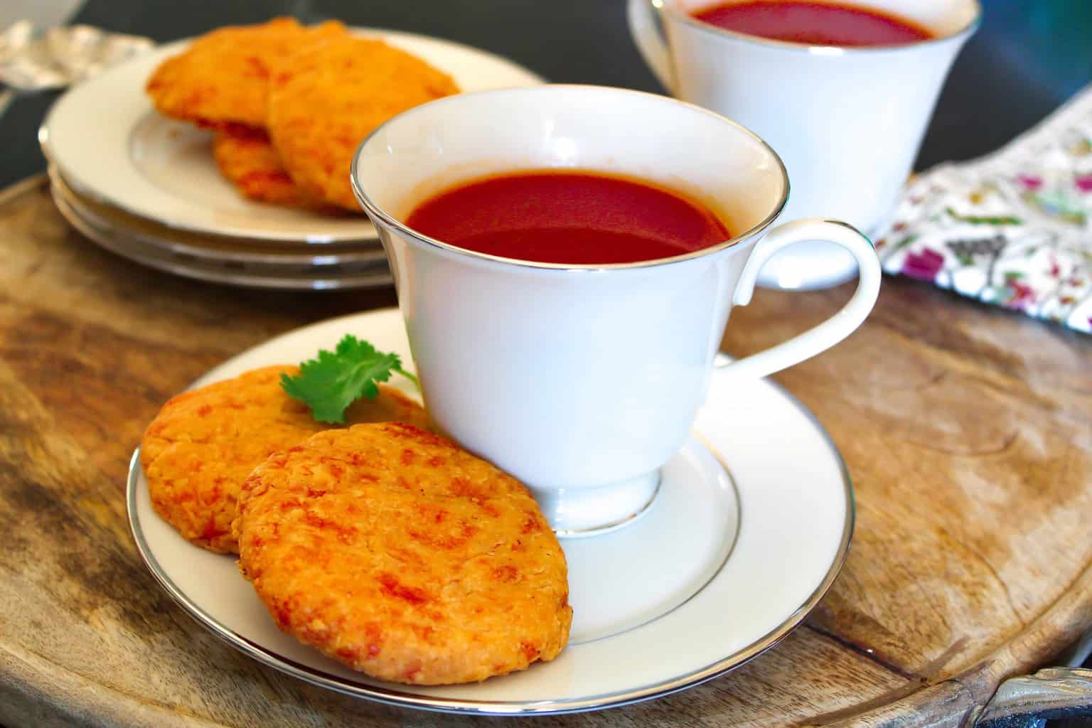 Non-Alcohol Southern Tomato Aperitif in a white china cup with two cheddar wafers on the saucer