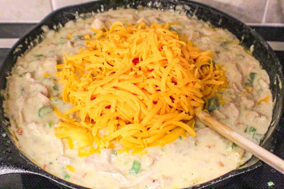 Shredded Cheddar cheese goes into the base of chicken spaghetti casserole
