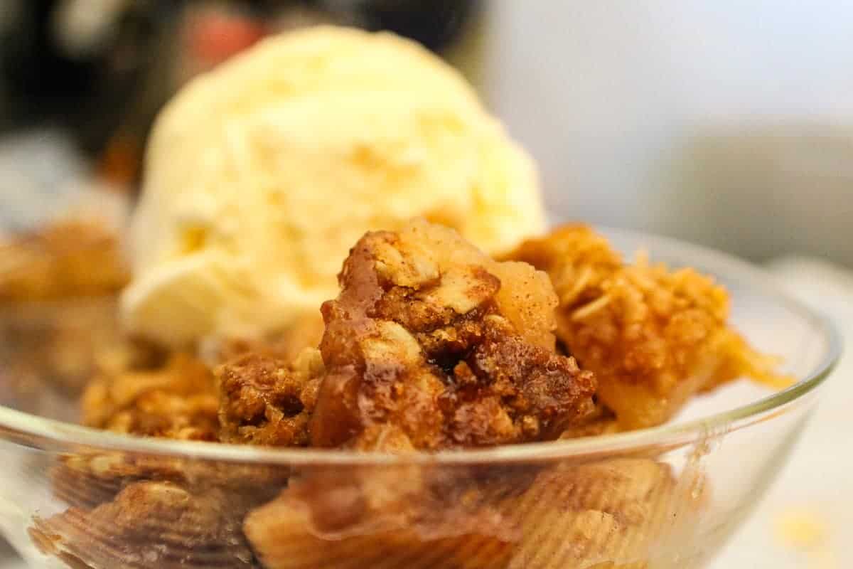 Apple crisp topped with vanilla ice cream.