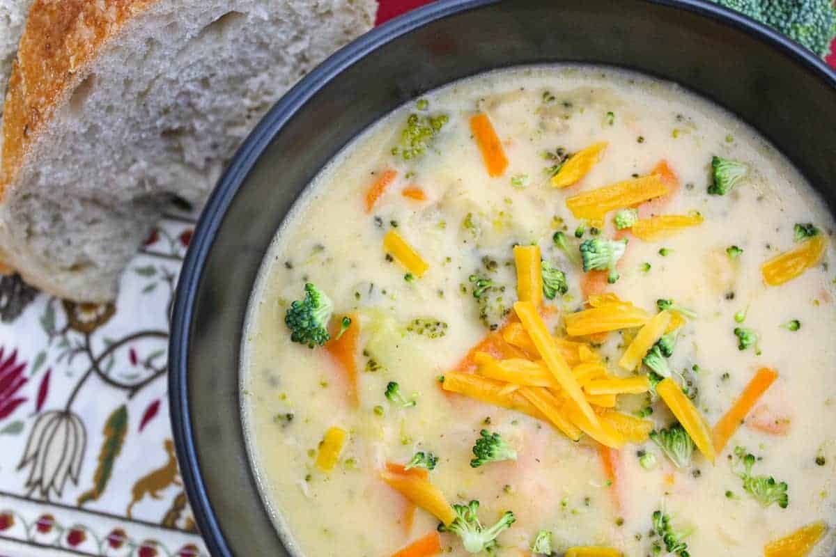 Homemade Broccoli Soup in a black bowl garnished with shredded cheese