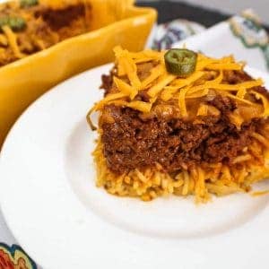 Slice of chili spaghetti pie on a white plate