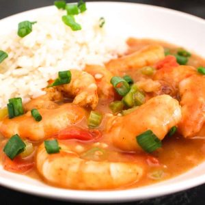 Close up image of Shrimp Etoufee and a side of rice garnished with green onions