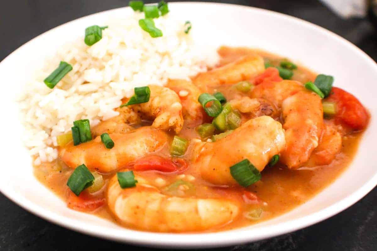 Etouffee in a white bowl with rice.