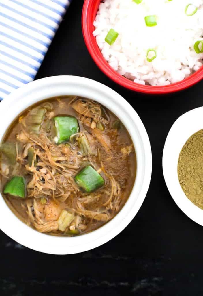 Bowl of gumbo with a side of rice and file powder