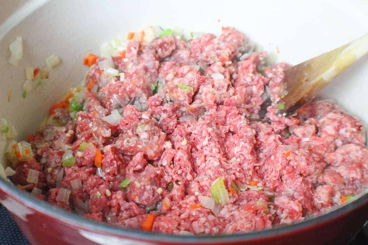 Ground beef, chopped vegetables in stockpot