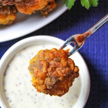 Holiday Sausage Ball on fork resting over honey mustard dip