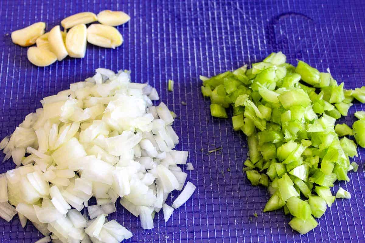 Chopped onion, celery and garlic on cutting board.