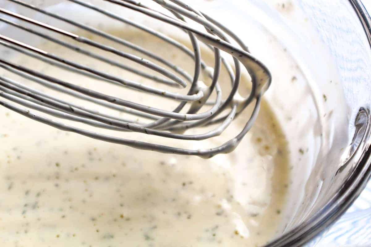 Whisk in bowl coated with dressing.