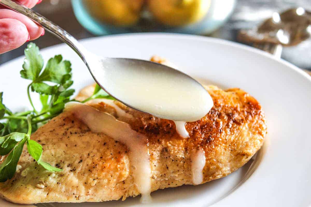 Lemon Sauce being drizzled over chicken breast