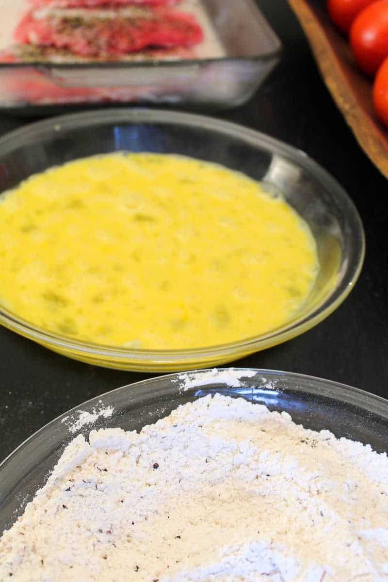 Two pie plates one with beaten eggs and one with flour