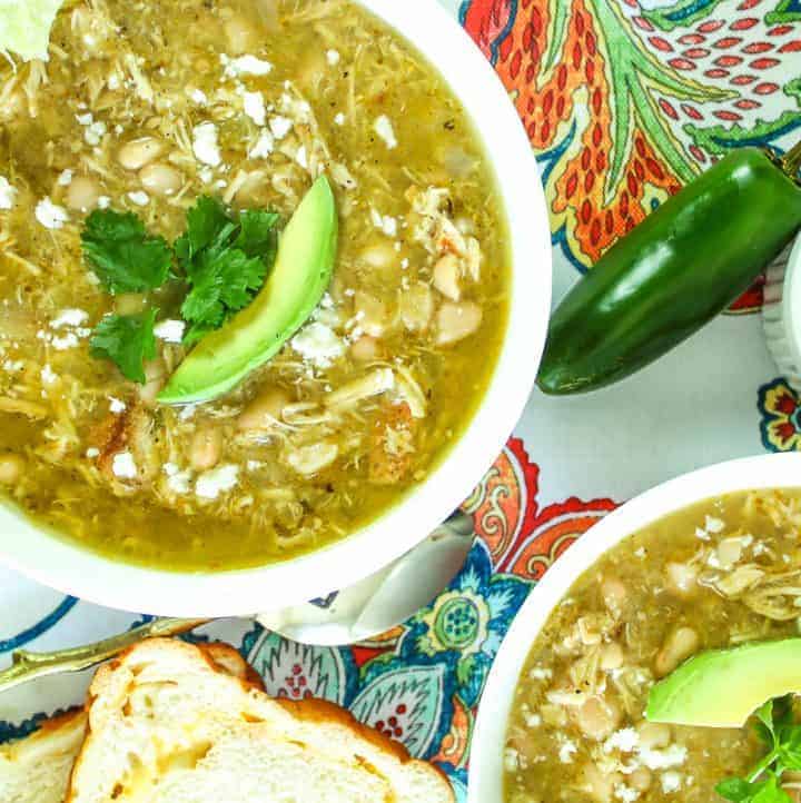 Green chile soup garnished with avocado.