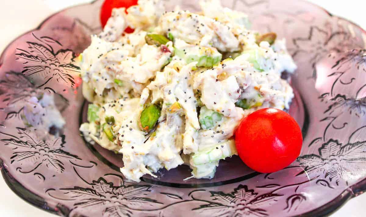 pistachio chicken salad on purple luncheon plate.