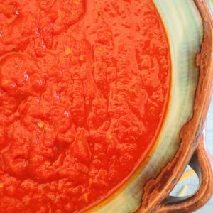 San Marzano pasta sauce in green bowl with wooden spoon