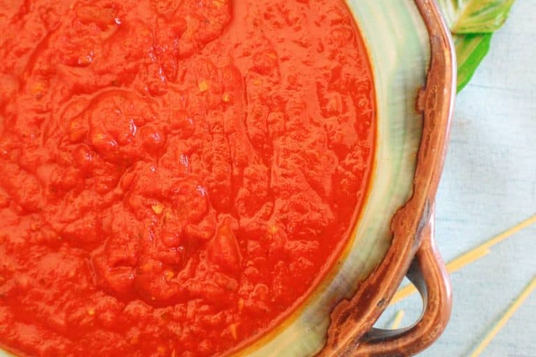 San Marzano pasta sauce in green bowl with wooden spoon