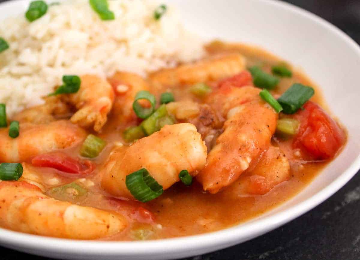 Shrimp Etouffee in a white bowl with a side of white rice.