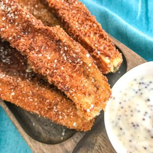 Strips of fried eggplant sticks on a wooden plate