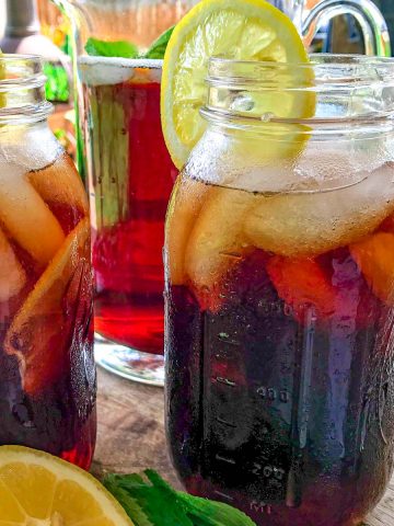 Mason jars full of iced tea with lemon on patio table