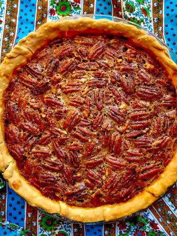 Whole pecan pie on colorful tablecloth