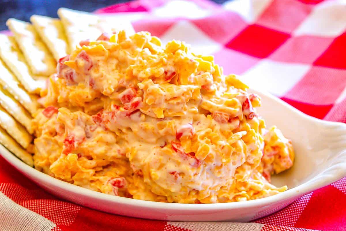 Huge scoop of pimento cheese on a white serving platter with a side of saltines