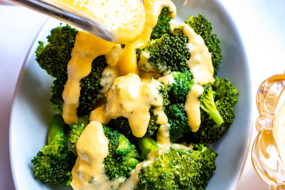 Cheddar cheese sauce drizzled over broccoli