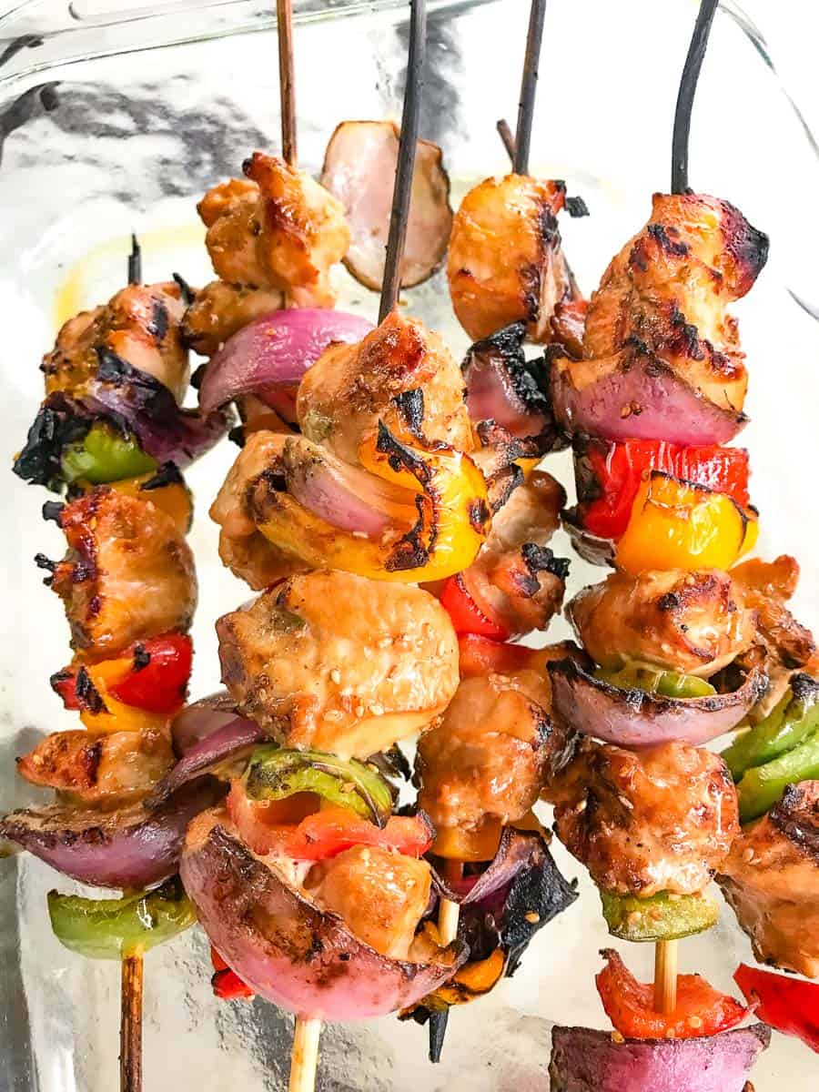 Grilled chicken and vegetable skewers in glass pan