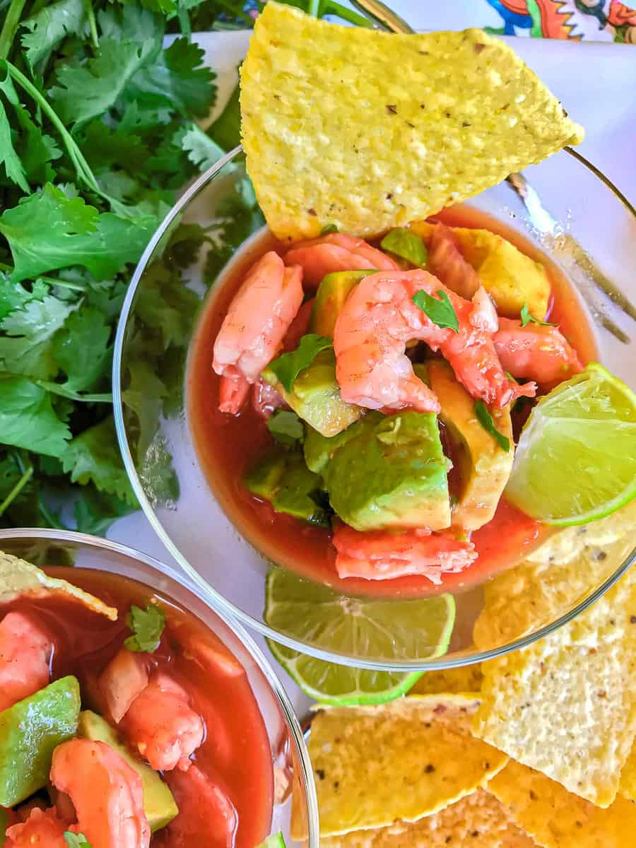 Mexican shrimp cocktails in glass bowls with lime garnish and tortilla chip