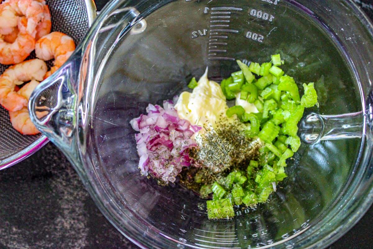 Shrimp salad ingredients in clear bowl