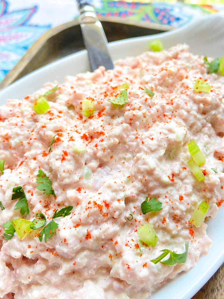 Deviled ham dip spread in a white bowl garnished with parsley