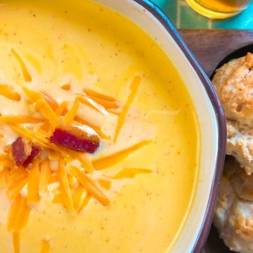 Cheese soup garnished with bacon and shredded cheddar