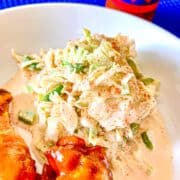 Creamy Creole Coleslaw on white plate with a side of chicken wings