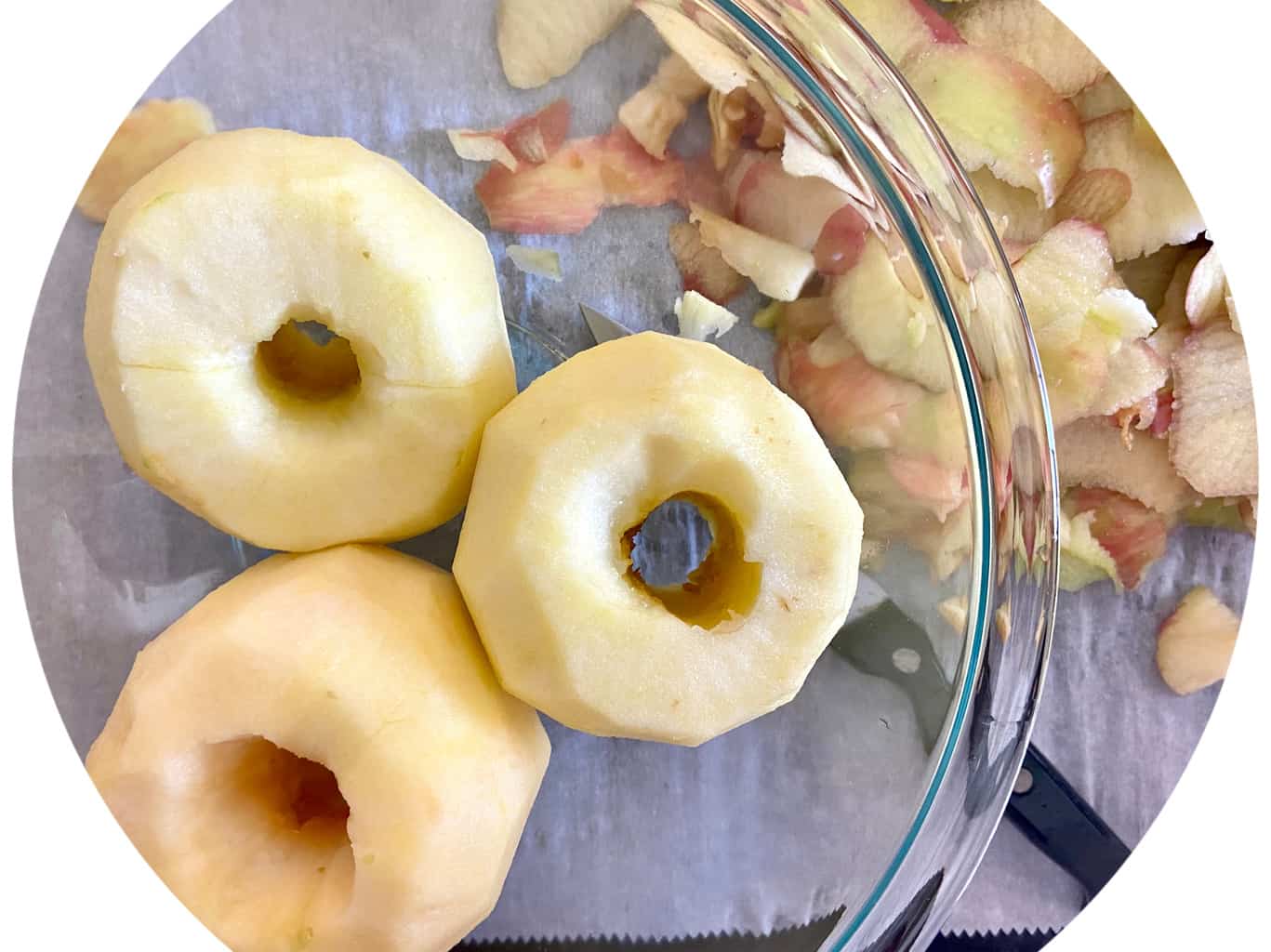 Three cored and peeled apples in a glass bowl