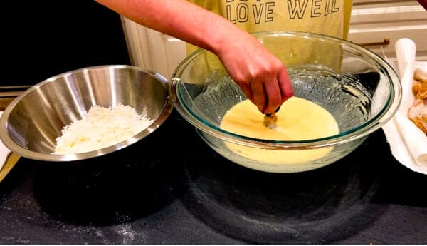Shrimp being dipped in batter