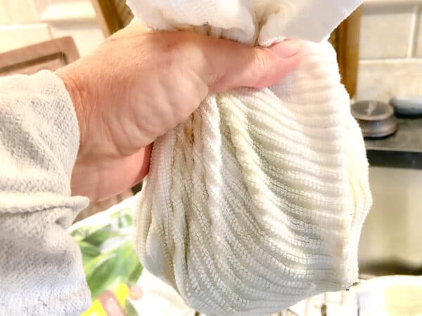 White dish towel full of spinach