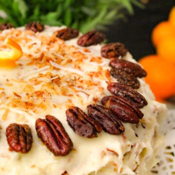 Orange Italian Cream Cake garnished with pecan halves and toasted coconut