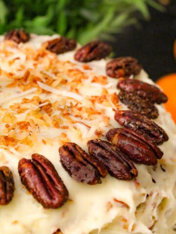 Orange Italian Cream Cake garnished with pecan halves and toasted coconut