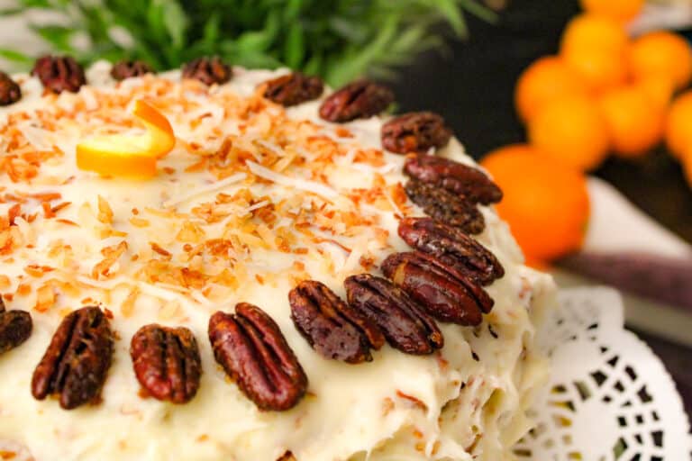 Orange Italian Cream Cake garnished with pecan halves and toasted coconut
