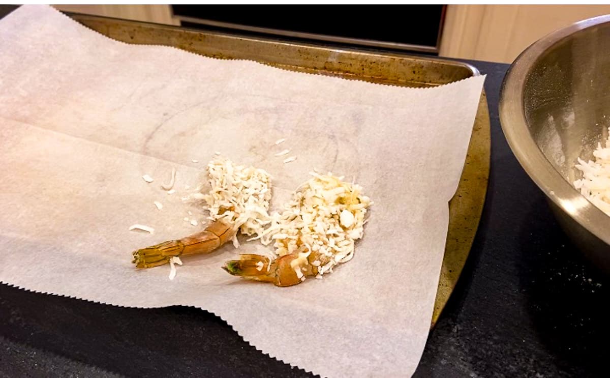 Coconut coated shrimp on baking sheet with parchment