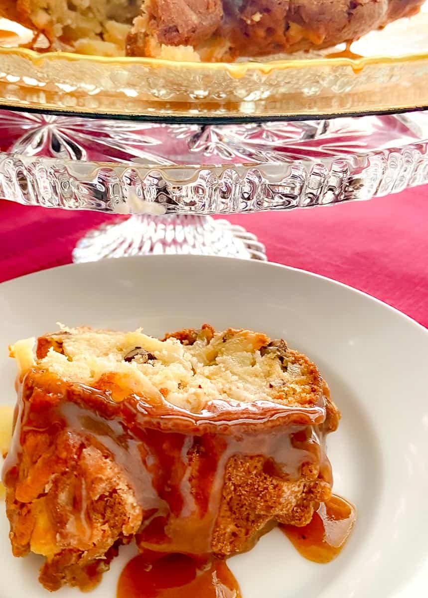 Sliced apple cake on white plate with glaze